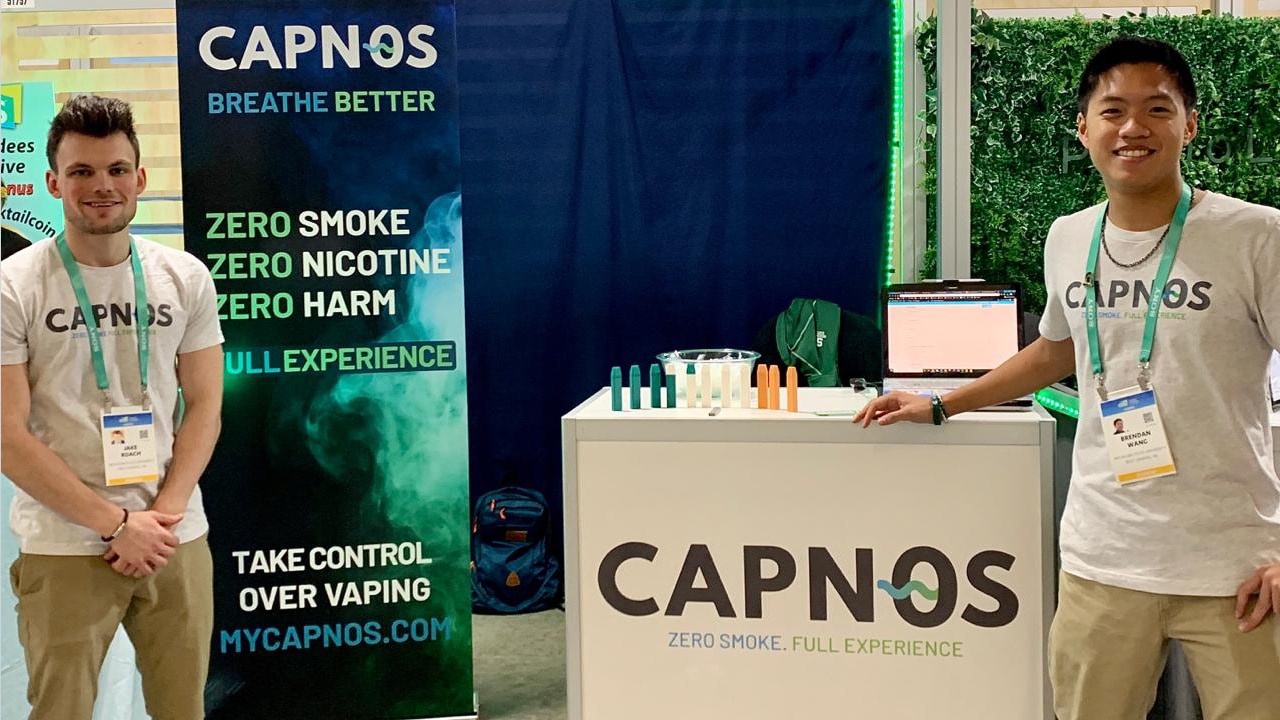 Jake Roach, marketing junior, and Brendan Wang, supply chain sophomore, stand at the CAPNOS corporate career both showcasing their safe alternative to vaping product at CES 2020.