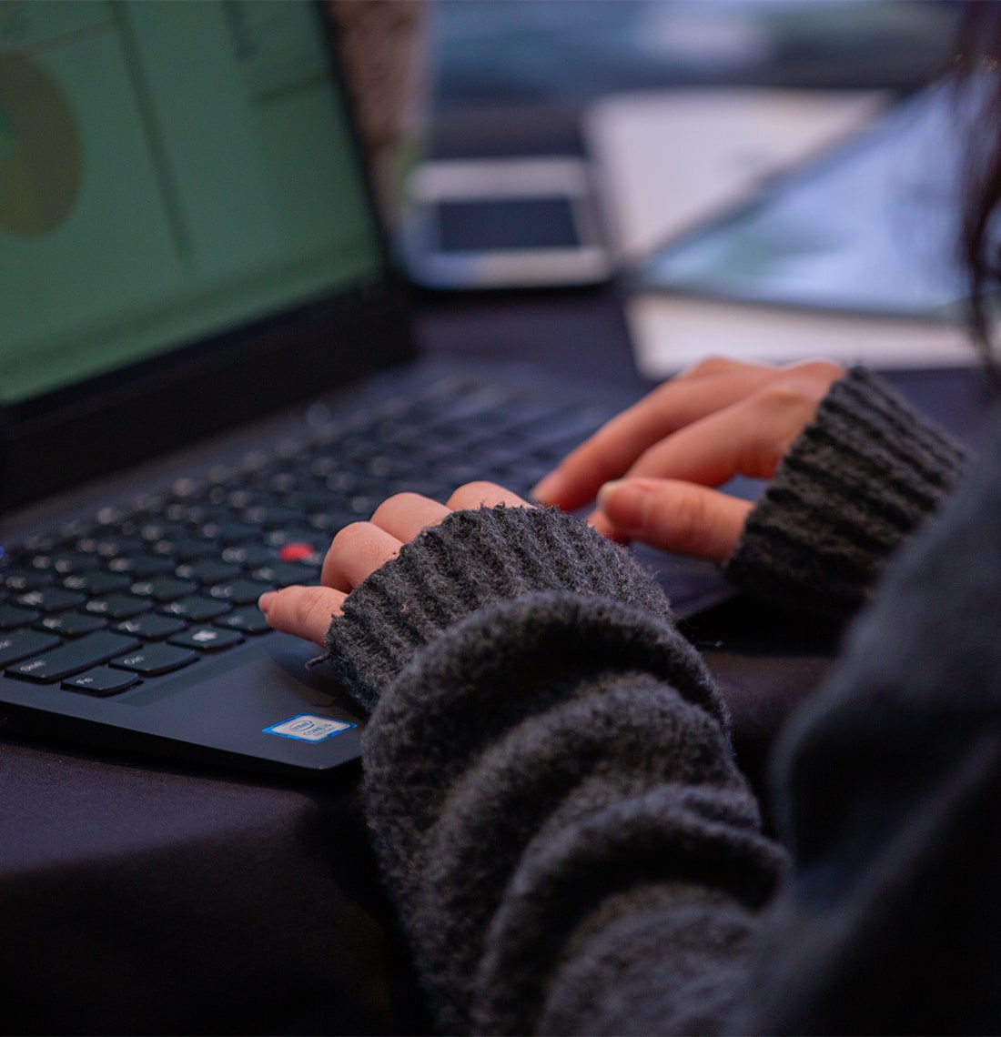 Close-up on a woman's hands as she types on a laptop.